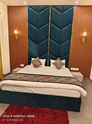 A bed with a quilted headboard, two bedside lamps, and a patterned bedspread.