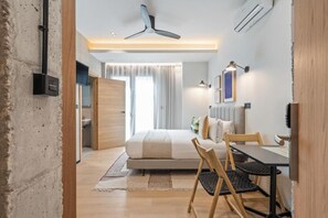A modern hotel room with a bed, a desk, and a chair. There is a ceiling fan, a window with curtains, and a wall-mounted TV. - Dobo Madrid Moncayo (Madrid)