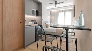 A compact kitchen with modern appliances, a dining area with a table and chairs, and a ceiling fan. - Dobo Madrid Moncayo (Madrid)