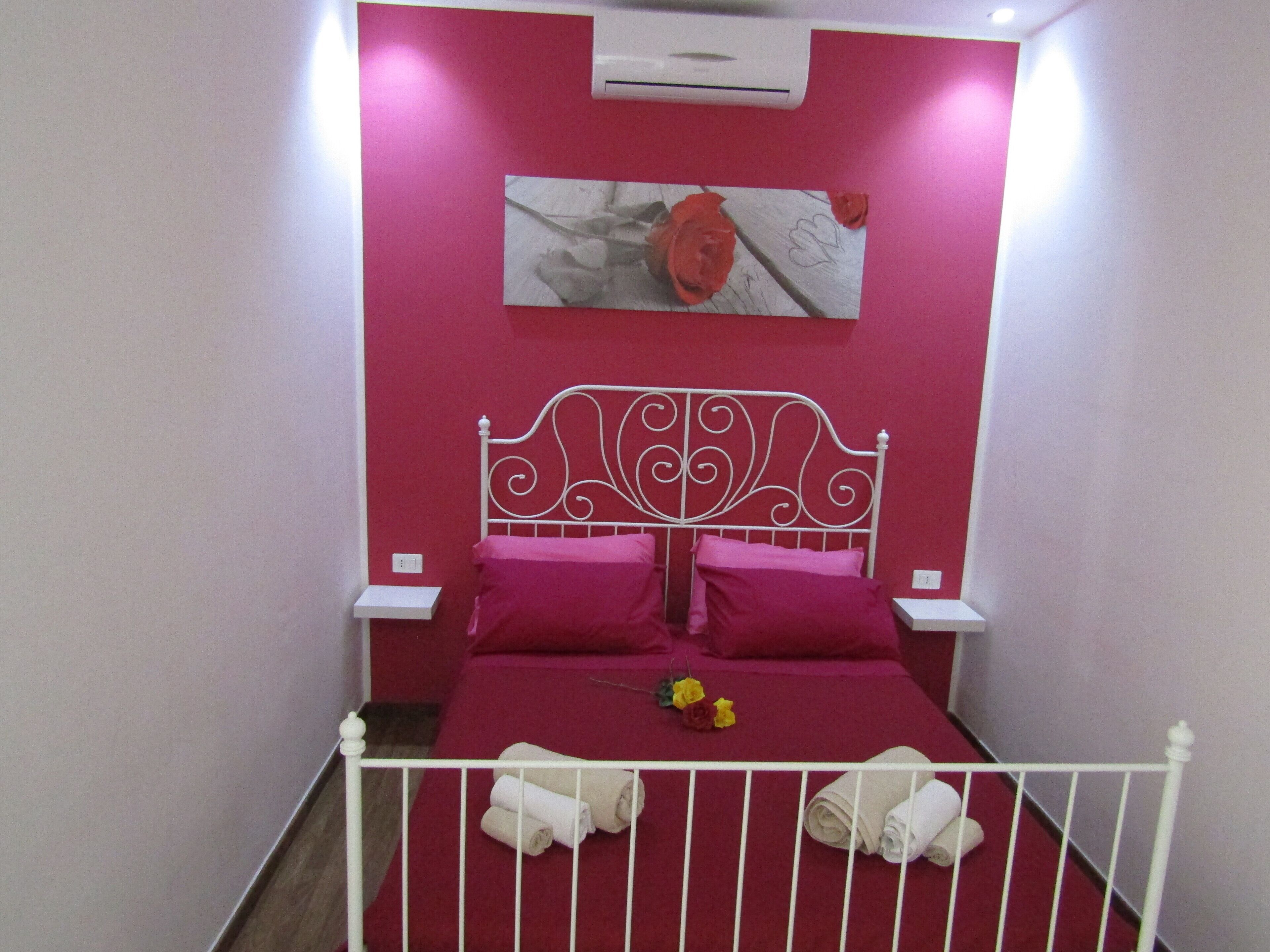 Une chambre avec un lit, des oreillers et un climatiseur fixé au mur.