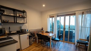 A compact kitchen with a dining area, a small refrigerator, and a table with chairs.