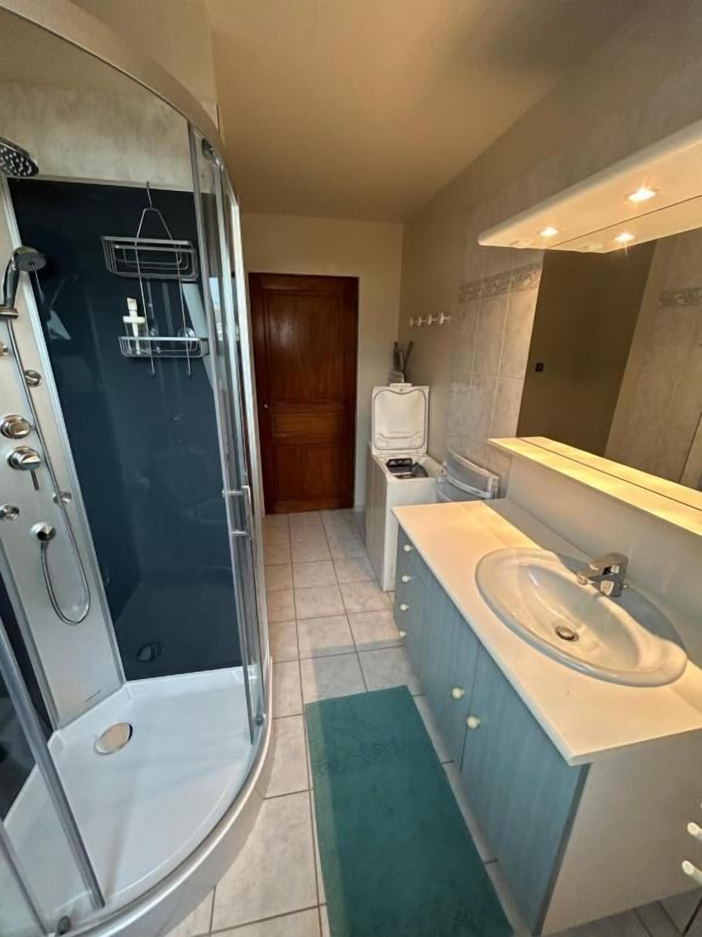 A bathroom with a shower, sink, and toilet.