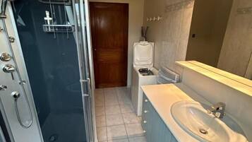 A bathroom with a shower, sink, and toilet.