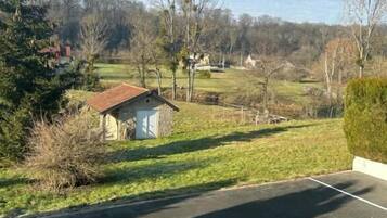 A parking area with a small shed and a grassy field in the background.