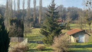 A rural landscape with a stone building, a fenced area, and a road. - Les Bords de la Lizaine (Hericourt)