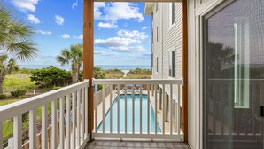 A wooden deck with a pool, overlooking a beach and ocean. - Dog Friendly-Windy Village-Oceanfront-Sleeps6-2br/2ba-Full Kitchen-Free Parking (North Myrtle Beach)