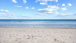 A beach with footprints leading to the water, a clear sky, and the ocean in the background. - Dog Friendly-Windy Village-Oceanfront-Sleeps6-2br/2ba-Full Kitchen-Free Parking (North Myrtle Beach)