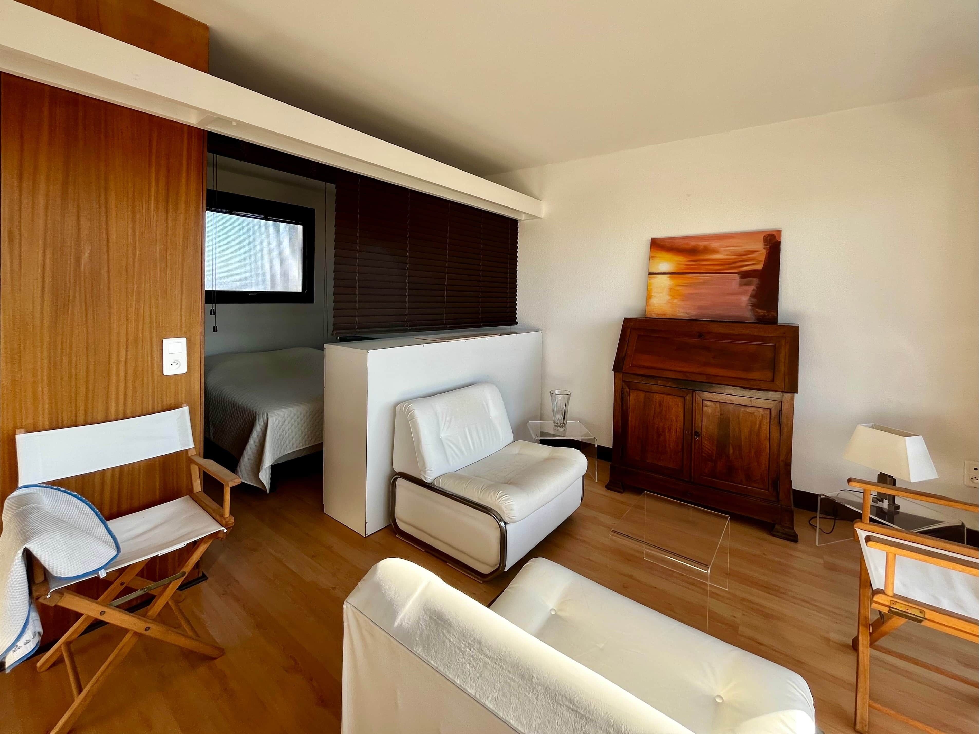 A compact living space with a bed, a sofa, a small table, and a cabinet.