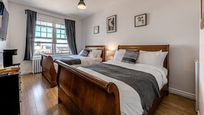 A bedroom with two beds, a view of the city, and a wooden floor. - Double room river view (Québec)