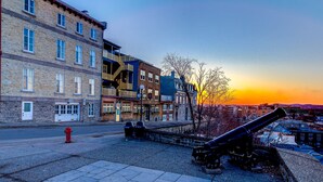 A historic building with multiple stories, a fire hydrant, and a cannon in the foreground. - Double room river view (Québec)