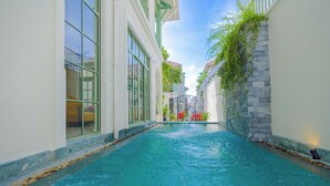 A narrow pool with clear blue water, surrounded by white walls and large windows. - Fortune Villa Phu Quoc (An Thoi)
