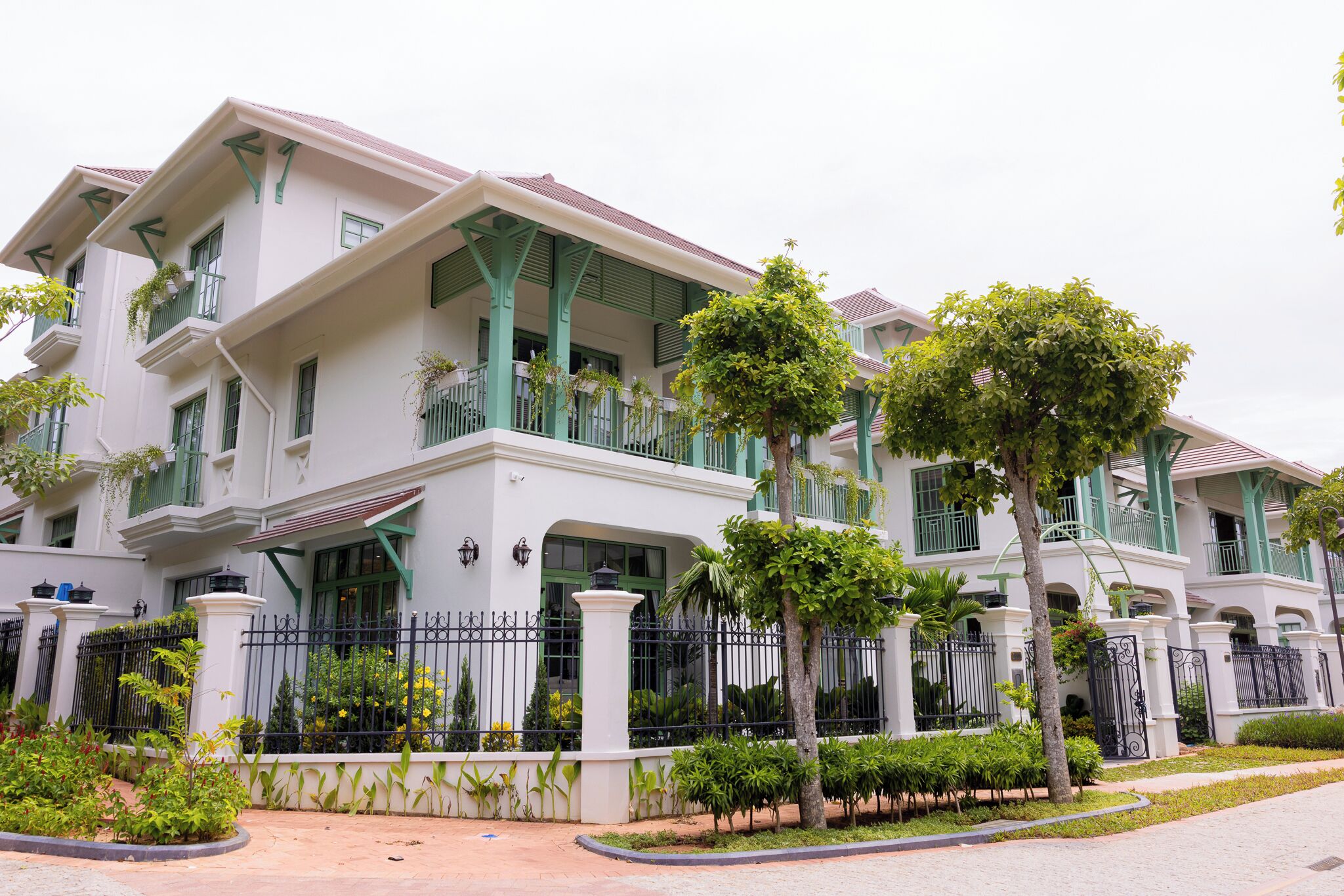 A multi-story residential building with balconies, a gated entrance, and well-maintained landscaping.