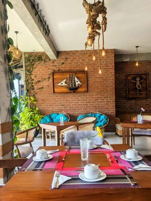 Ein gemütliches Restaurant mit Backsteinwänden, Holzmöbeln und hängenden Lampen.