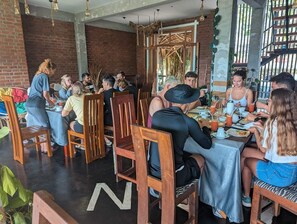 A restaurant with wooden chairs and tables, brick walls, and hanging lights. - ella dream mount (Ella)