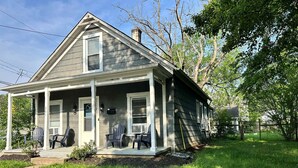 A two-story house with a porch, a chimney, and a small garden area. - Elm Corner, 2 bedroom family house in Historic Loveland (Loveland)