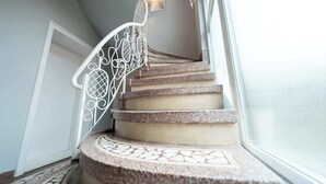 A spiral staircase with a decorative metal railing and patterned floor tiles. - Joy City Stay Madgearu 2 (Timișoara)