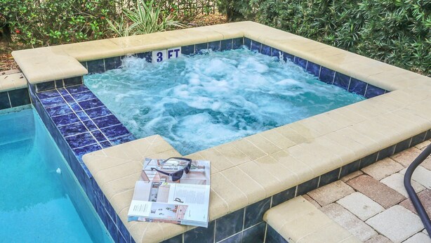 Un jacuzzi con una profundidad de 0,9 metros, rodeado por una zona de piscina con azulejos.
