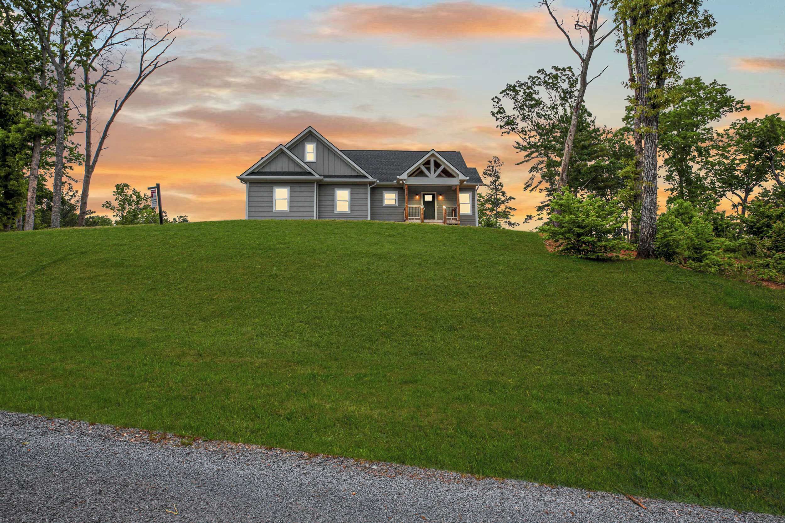 A two-story house with a front porch and a driveway.