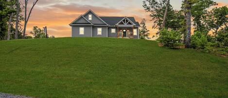 A two-story house with a front porch and a driveway.