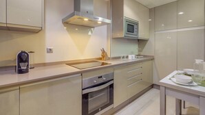 A modern kitchen with a built-in oven, microwave, and stainless steel range hood. - Islantilla Golf Holiday Home with Private Terrace, Wi-Fi, and Air Conditioning (Huelva)