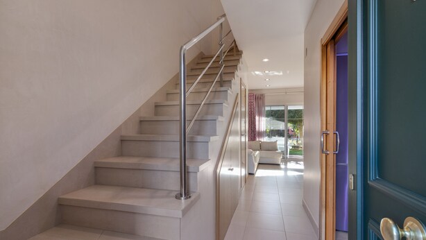 A modern interior with a staircase, a door, and a view into a living area. - Islantilla Golf Holiday Home with Private Terrace, Wi-Fi, and Air Conditioning (Huelva)
