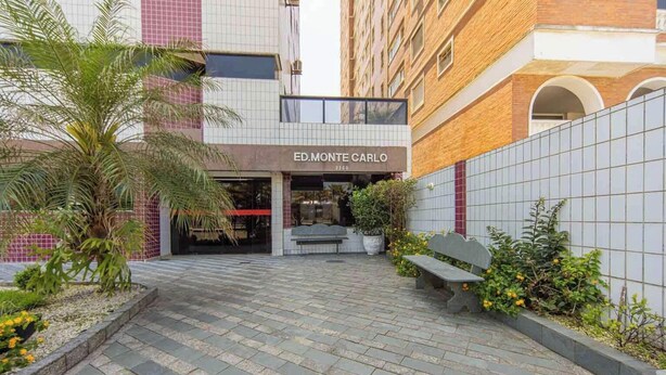 A building entrance with the sign "ED.MONTE CARLO 2380". - Apartamento na Praia Grande com vista mar (Praia Grande)
