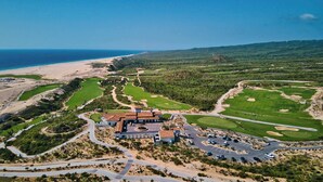 A golf course with a clubhouse, multiple greens, and a beach in the background. - Golf Villa Pacifico at Rancho San Lucas with ocean view (Cabo San Lucas)
