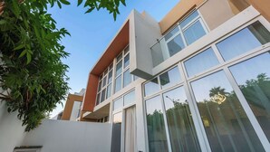 Un bâtiment moderne doté de grandes fenêtres et d’une façade blanche.