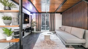Una sala de estar moderna con un sofá, una mesa de centro y estanterías con plantas.