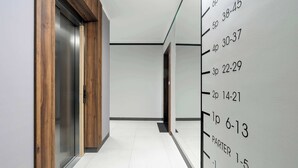 A hallway with a wooden door and a height chart on the wall. - Modern Apartment | Private Parking and Balcony (Poznań)
