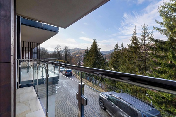 Balcony with outdoor seating and forest views.