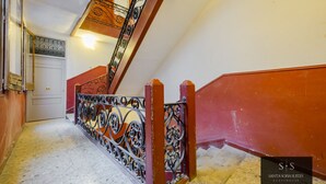 Eine Treppe mit aufwendigen Metallgeländern und roten Wänden.