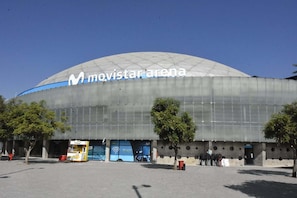 Un estadi amb una gran cúpula i el text 'movistar arena' a la façana.