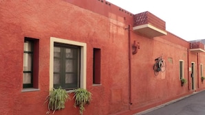 Un bâtiment rouge avec deux fenêtres, une porte et un vélo garé à l’extérieur.