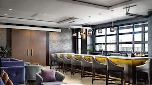 A modern bar area with a bar counter, seating, and large windows. - Near Great America Theme Park + Breakfast & Pool (Milpitas)