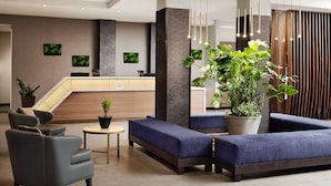 A modern lobby with a reception desk, seating area, and potted plants. - Near Great America Theme Park + Breakfast & Pool (Milpitas)