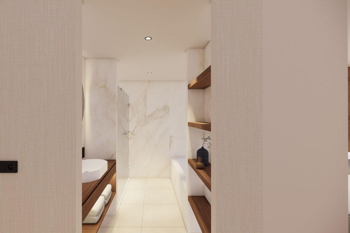 A modern bathroom with a marble wall, a white sink, and wooden shelves.