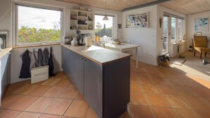 A modern kitchen with a central island, built-in shelves, and a view of the outdoors. - Awesome home in Malling with WiFi (Malling)