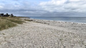 A sandy beach with a grassy area and a view of the sea under a cloudy sky. - Awesome home in Malling with WiFi (Malling)
