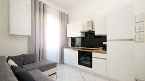 A modern kitchen with white cabinets, a black oven, and a wooden countertop. - Elmi 1 – Cool apartment with on-site parking  (Arona)