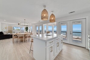 A spacious kitchen with a large island, white cabinetry, and a view of the ocean through large sliding doors. - Lost Palms. Great 2 bedroom 2 bath home that sits directly on the Gulf front. (Gulf Shores)