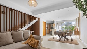 Una sala moderna con sofá, mesa de centro y una escalera.