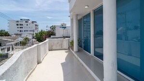 Un edificio moderno con balcón, ventanas amplias y vistas despejadas del entorno.