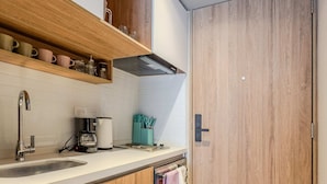 Una cucina moderna con mobili in legno, un lavello in acciaio inossidabile e una macchina da caffè integrata.