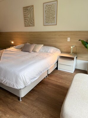 Ein ordentlich eingerichtetes Schlafzimmer mit Bett, Nachttischen und einem Beistelltisch.