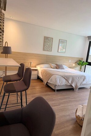 A modern hotel room with a bed, bedside table, lamp, and two framed artworks on the wall. - NOK Beautiful 2BR Apartment in El Poblado (Medellín)