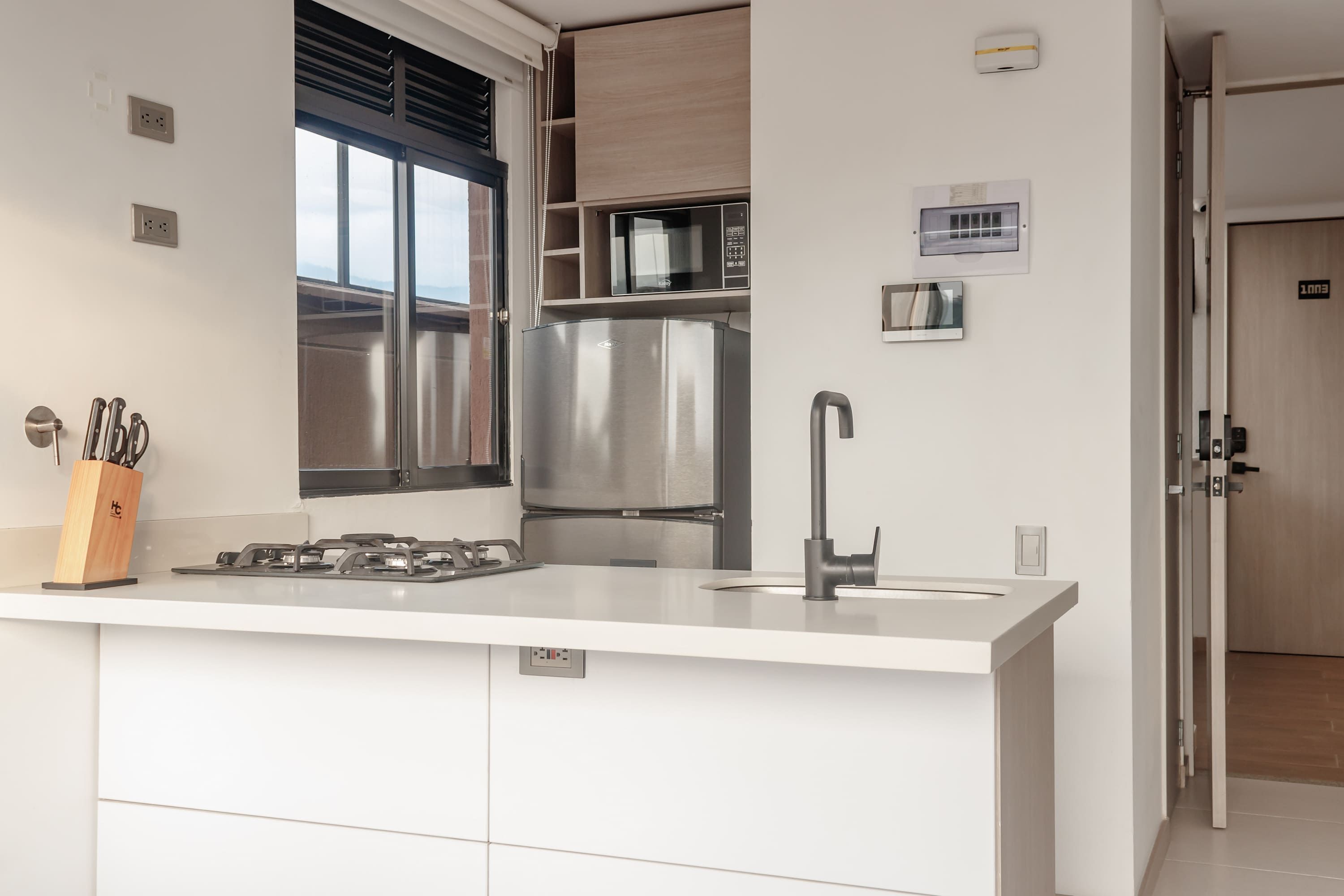 Una cucina moderna con frigorifero in acciaio inossidabile, forno a microonde e piano cottura a gas.