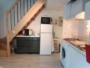 A compact kitchen with a microwave, toaster, and refrigerator. A wooden staircase leads to a lofted area. - Duplex in Argelès-sur-Mer with parking (Argelès-sur-Mer)