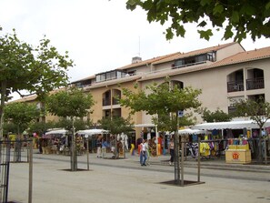 Eine Straße mit Marktständen und einem Gebäude mit Balkonen.