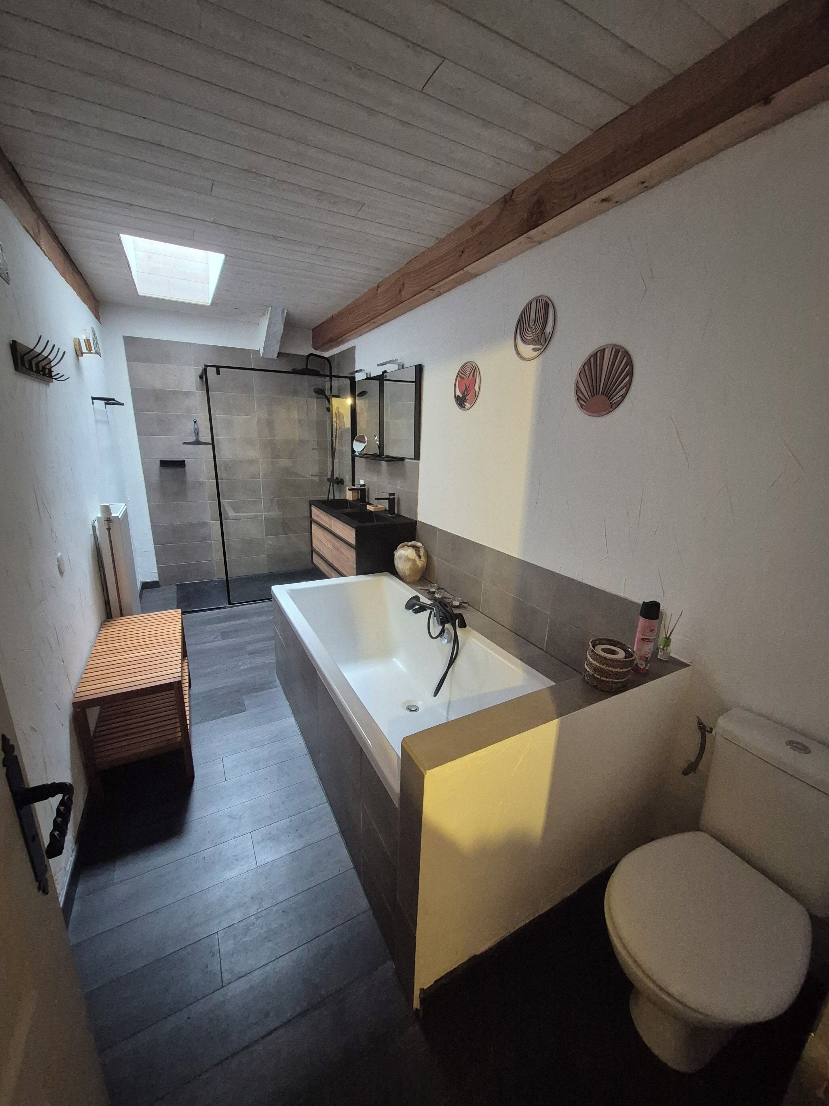 A modern bathroom with a large bathtub, a toilet, and a shower area.